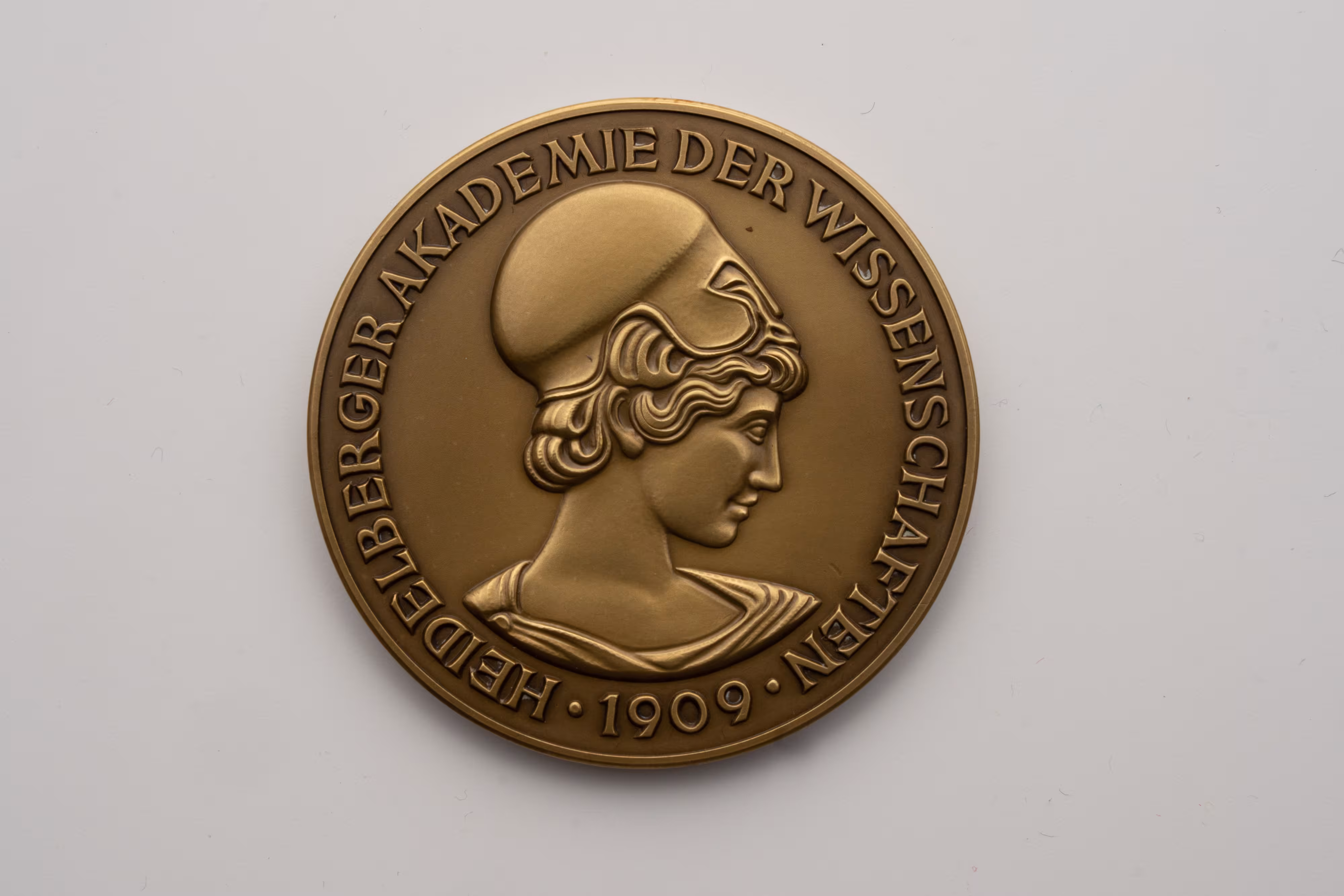 La médaille de bronze représente la tête d'Athéna, déesse grecque des sciences. Sur le pourtour de la médaille figure l'inscription « Heidelberger Akademie der Wissenschaften 1909 » (Académie des sciences de Heidelberg 1909).   