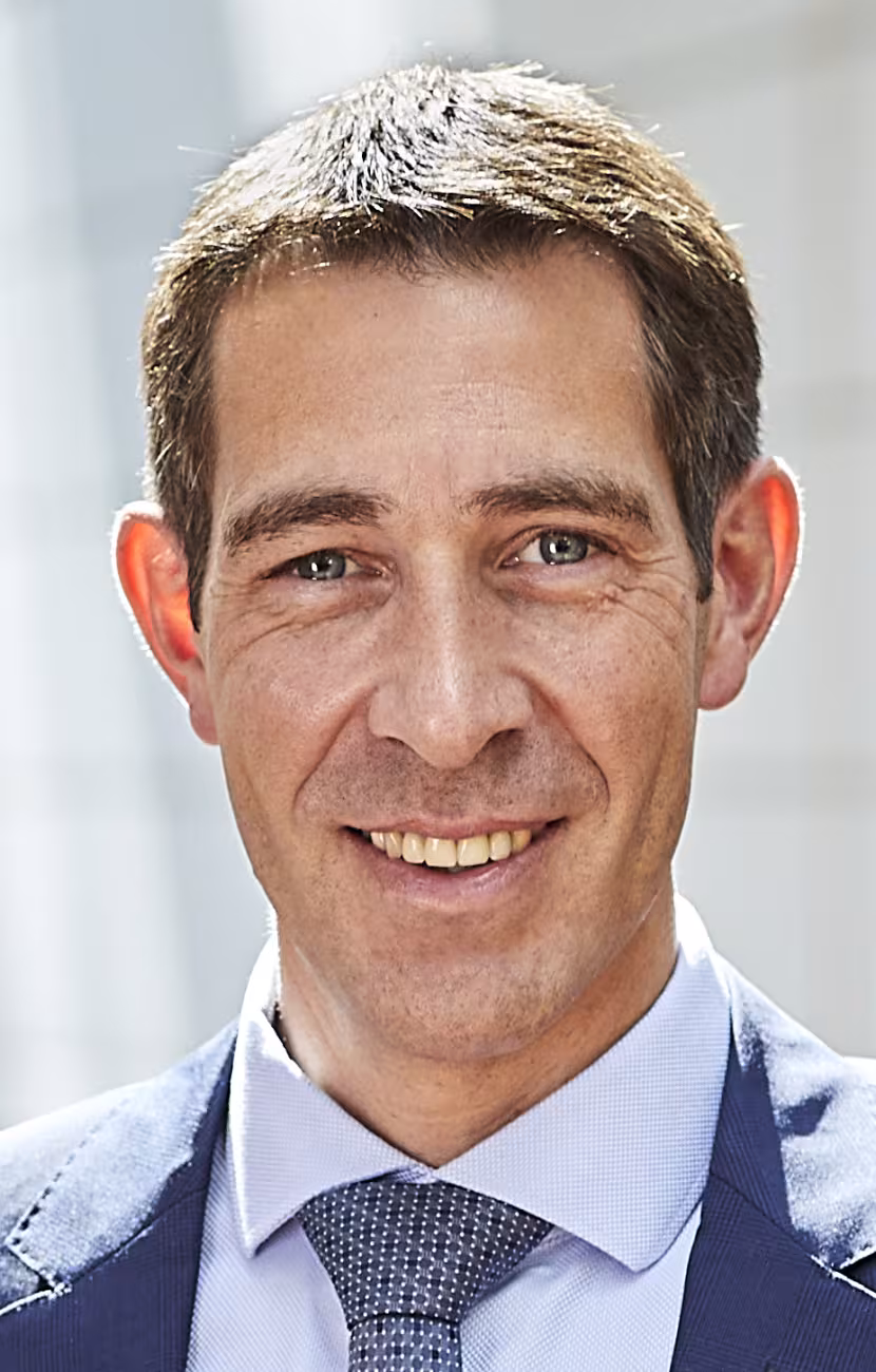 Photo portrait de Klaus Blaum. Vue de face d'un homme qui sourit au spectateur. Il ne porte pas de lunettes et a les cheveux bruns courts.